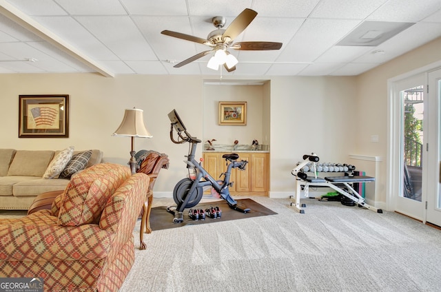 workout area with carpet, a drop ceiling, ceiling fan, and baseboards