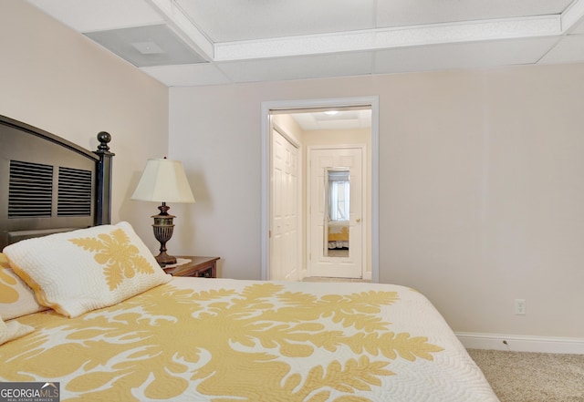 bedroom featuring carpet floors, a drop ceiling, and baseboards