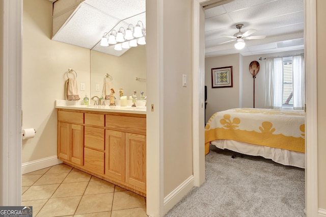 bedroom with baseboards, light colored carpet, connected bathroom, and light tile patterned flooring