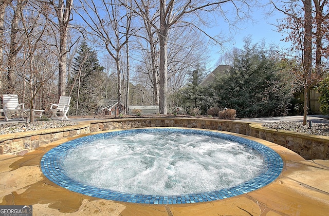 view of swimming pool featuring an outdoor hot tub