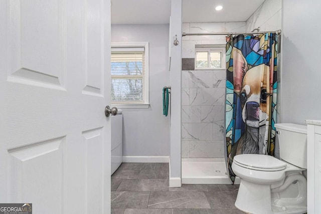 full bathroom with toilet, a stall shower, and baseboards