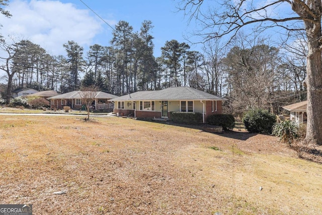 single story home with covered porch, brick siding, and a front yard