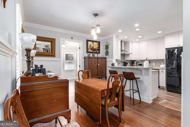 dining area with ornamental molding, wood finished floors, and recessed lighting