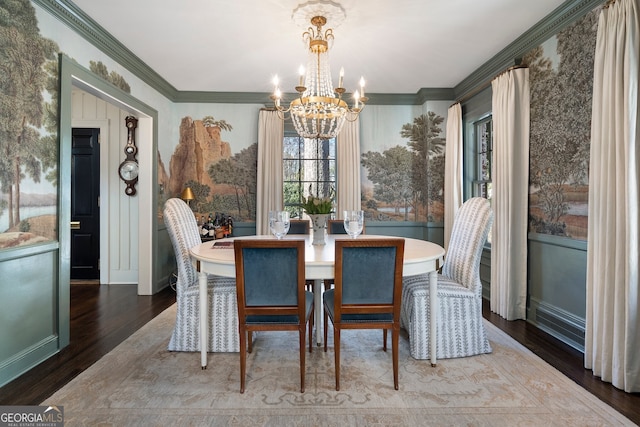 dining space featuring wallpapered walls, wainscoting, ornamental molding, wood finished floors, and a chandelier