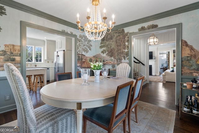 dining room with dark wood-style floors, a fireplace, ornamental molding, and a chandelier