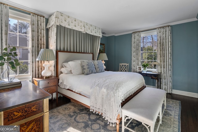 bedroom featuring baseboards, wood finished floors, and crown molding