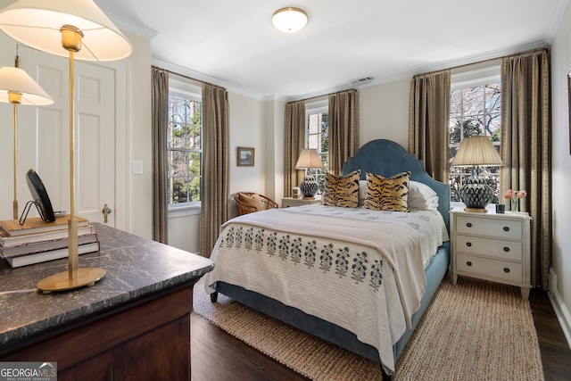 bedroom with dark wood-type flooring and crown molding