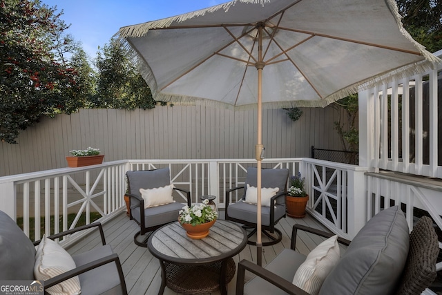 wooden terrace with outdoor lounge area and fence