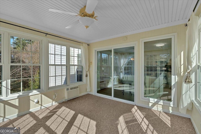 unfurnished sunroom with a ceiling fan and a wall mounted air conditioner