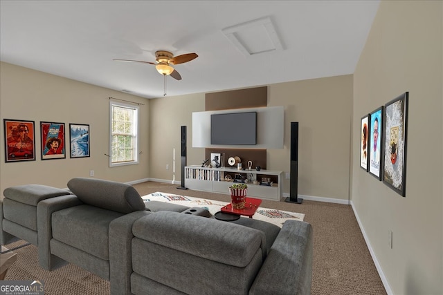 carpeted living room with attic access, ceiling fan, and baseboards