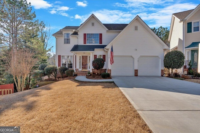 traditional-style home featuring driveway, a garage, and a front lawn