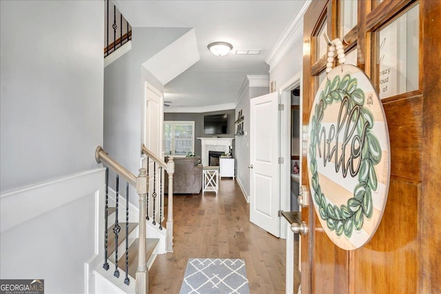 corridor featuring stairway, visible vents, ornamental molding, and dark wood-type flooring