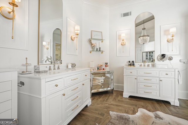 full bath with ornamental molding, two vanities, visible vents, and a sink