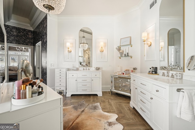 ensuite bathroom with ensuite bathroom, a sink, two vanities, visible vents, and crown molding