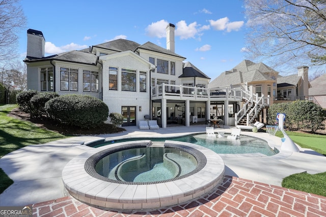 back of house with french doors, a chimney, a patio area, and brick siding