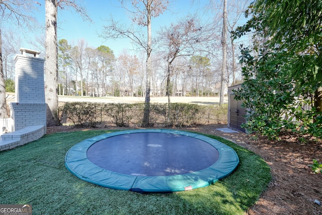 view of swimming pool with a trampoline and an outbuilding