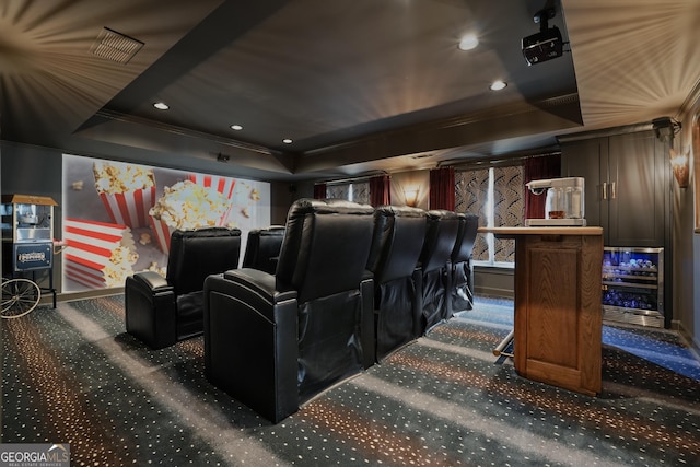 cinema room featuring a tray ceiling, carpet, crown molding, recessed lighting, and visible vents