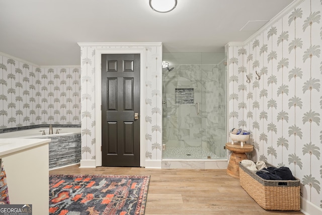 full bathroom featuring a stall shower, wood finished floors, and wallpapered walls