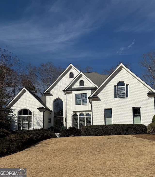 view of front of home featuring a front lawn and brick siding