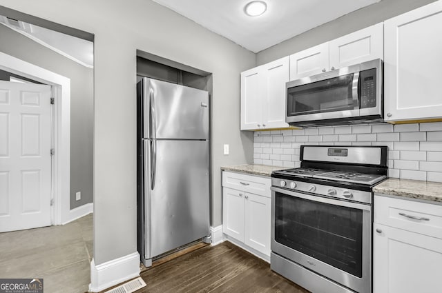 kitchen featuring tasteful backsplash, white cabinetry, and stainless steel appliances