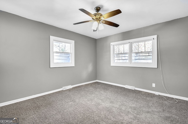 carpeted empty room featuring visible vents, baseboards, and a ceiling fan