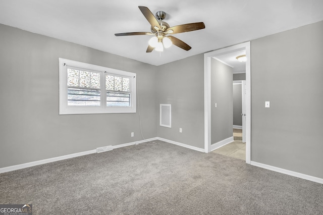 empty room featuring a ceiling fan, light carpet, visible vents, and baseboards