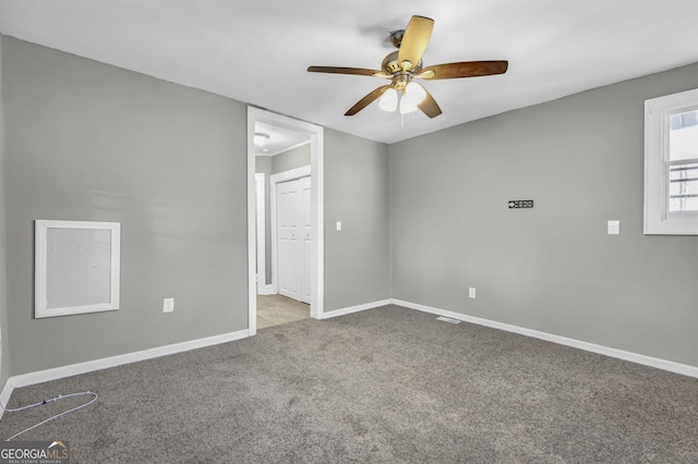 empty room with a ceiling fan, baseboards, and carpet flooring