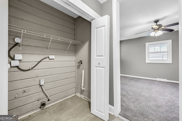 laundry area with carpet, ceiling fan, wooden walls, laundry area, and baseboards