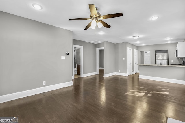 unfurnished living room featuring a ceiling fan, baseboards, and wood finished floors