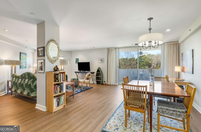 dining space with a notable chandelier, baseboards, wood finished floors, and recessed lighting