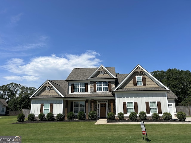 craftsman-style house with fence, board and batten siding, and a front yard