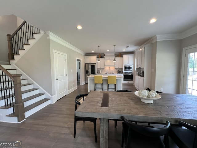 dining room with baseboards, stairs, ornamental molding, and dark wood finished floors