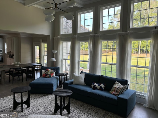 living area featuring a towering ceiling, crown molding, and wood finished floors