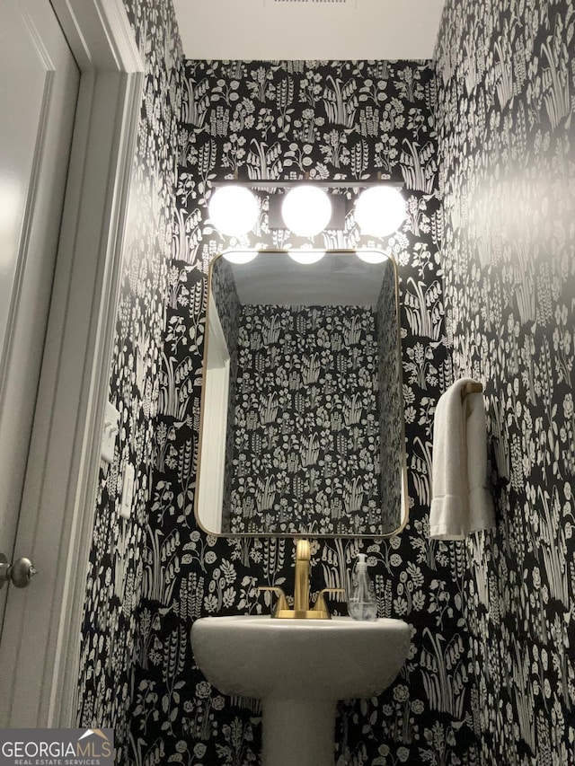 bathroom with wallpapered walls