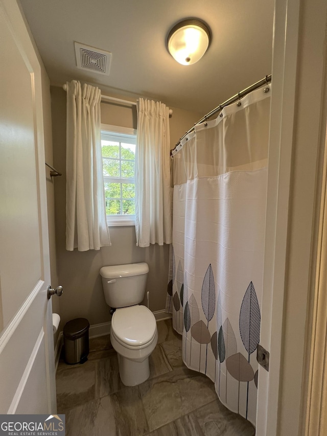 full bath featuring baseboards, visible vents, toilet, marble finish floor, and curtained shower