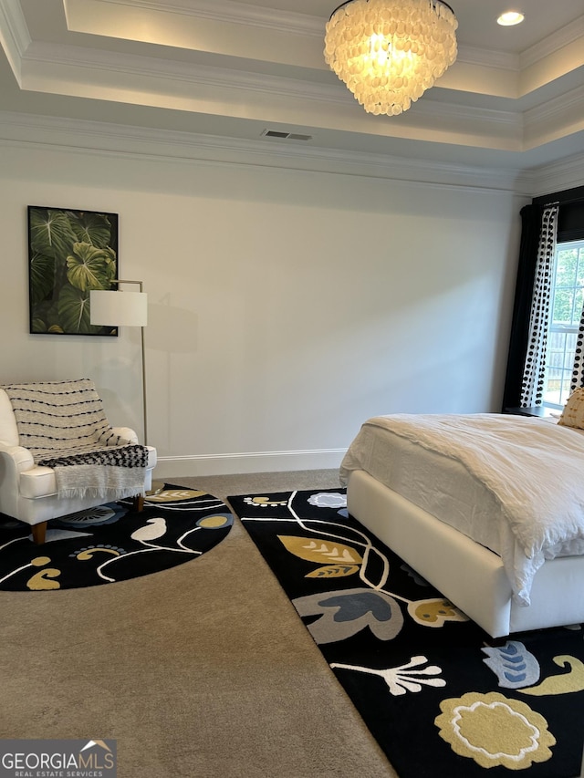 carpeted bedroom with a tray ceiling, visible vents, crown molding, and baseboards