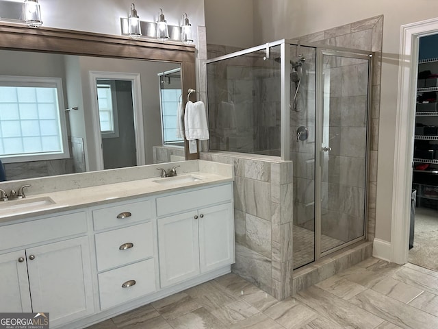 bathroom featuring a stall shower, a sink, and double vanity