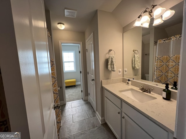 full bath featuring visible vents, vanity, and baseboards