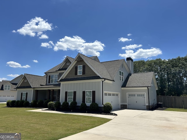 view of front of property featuring driveway, a chimney, fence, a front lawn, and board and batten siding