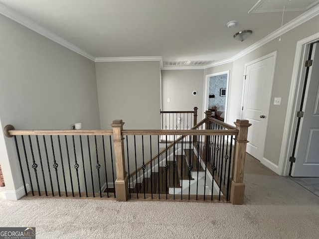 corridor with attic access, baseboards, an upstairs landing, crown molding, and carpet flooring