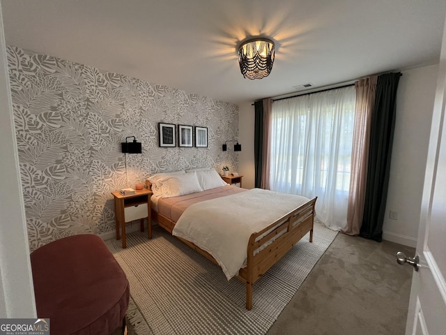 bedroom with baseboards, light colored carpet, visible vents, and wallpapered walls