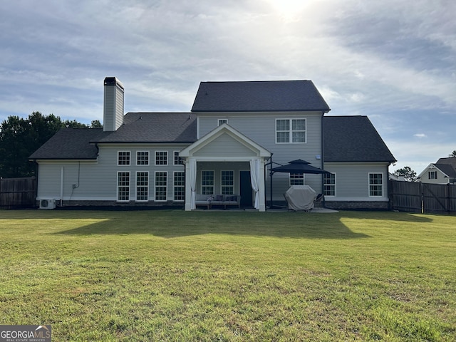 rear view of house featuring a patio, fence, a chimney, and a lawn