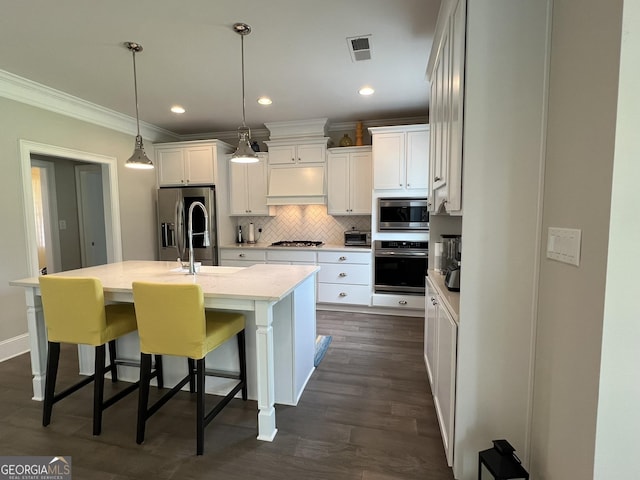 kitchen featuring white cabinetry, visible vents, appliances with stainless steel finishes, backsplash, and custom range hood