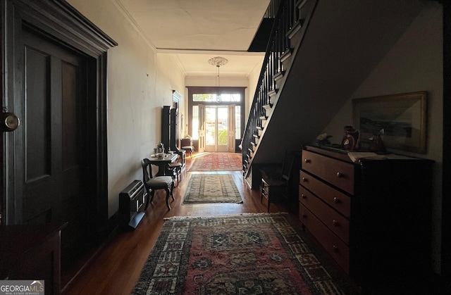 interior space with dark wood-type flooring, crown molding, and stairway