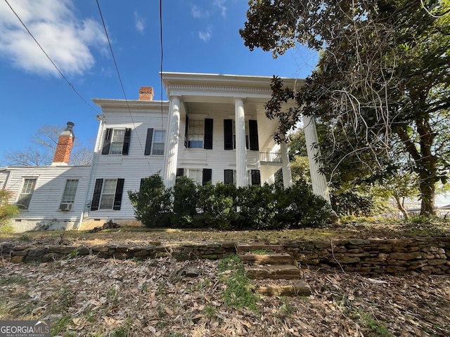 view of front of home with crawl space and a chimney