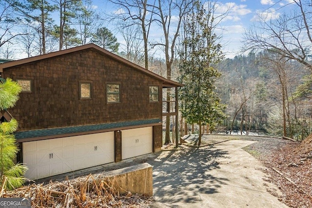 view of side of home with an attached garage and concrete driveway