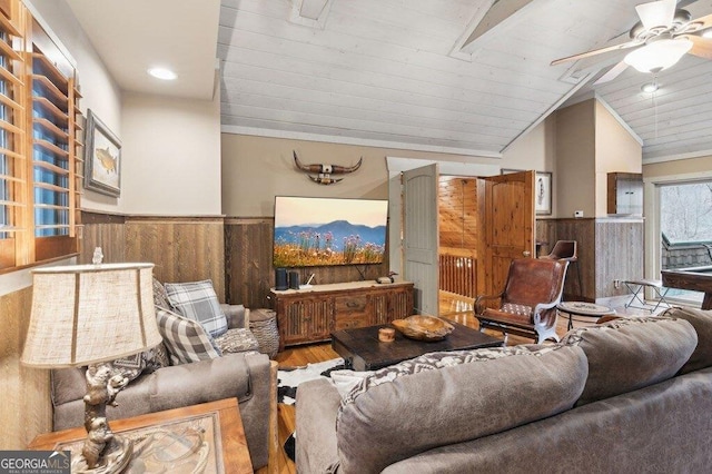 living area with wooden ceiling, wainscoting, vaulted ceiling, and wooden walls