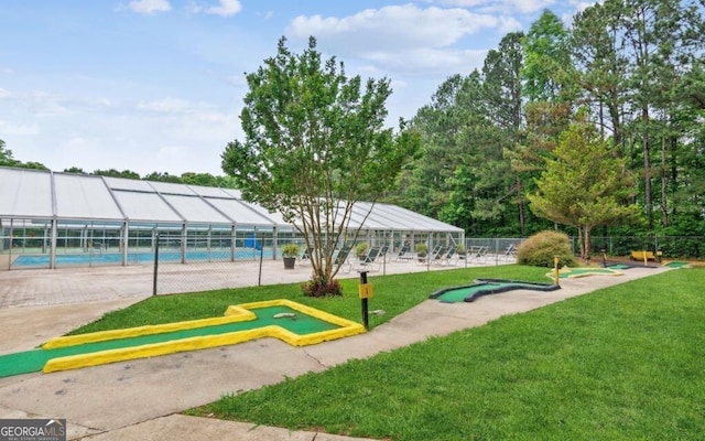 view of home's community with a yard, a swimming pool, and fence