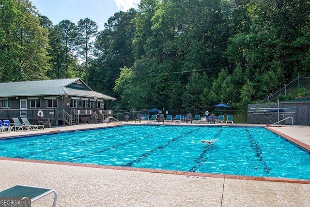 community pool featuring a patio area and fence