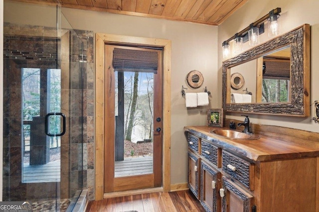 bathroom featuring wood finished floors, wooden ceiling, a shower stall, and vanity